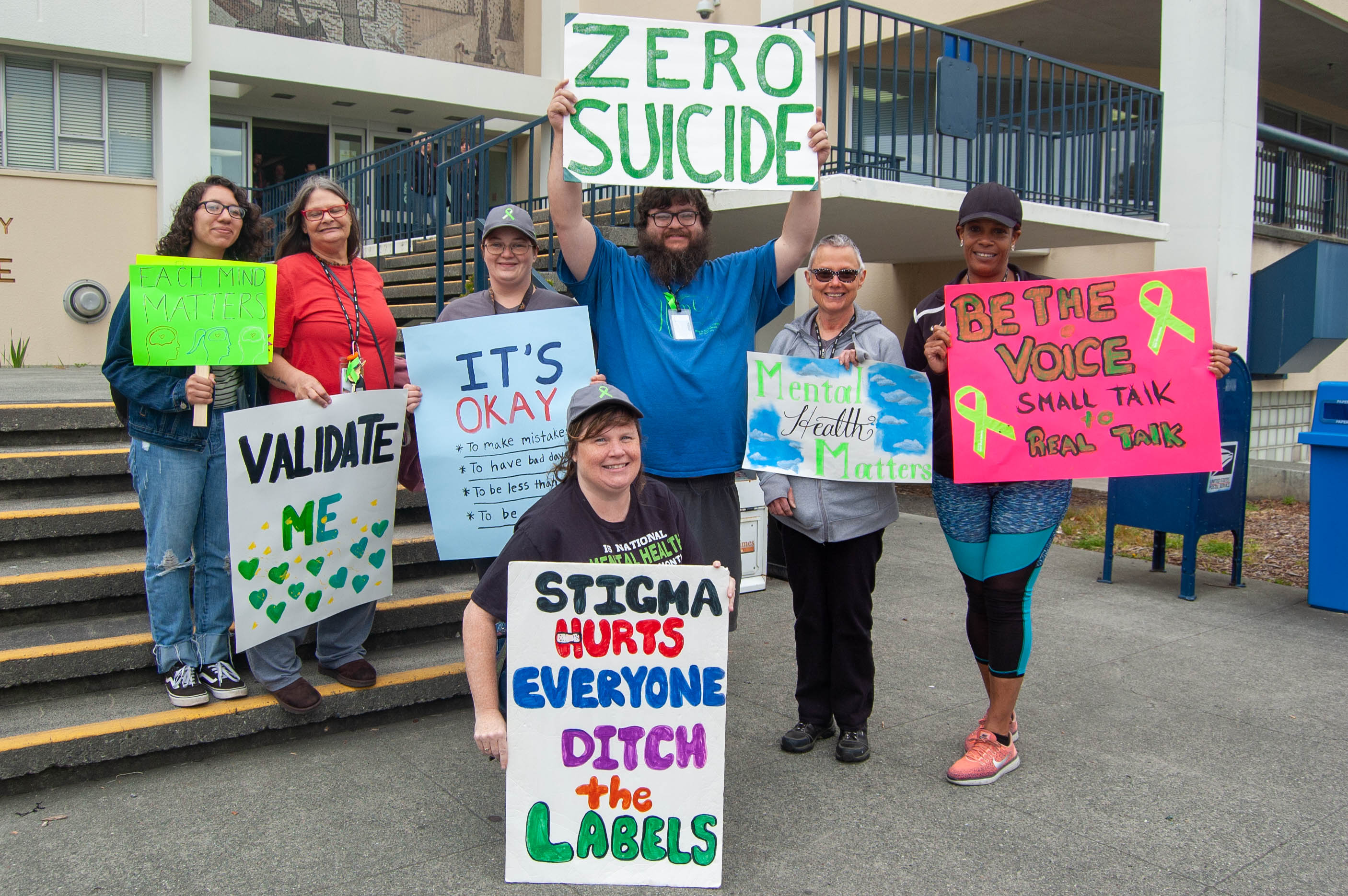 Group of people holding signs supporting mental health